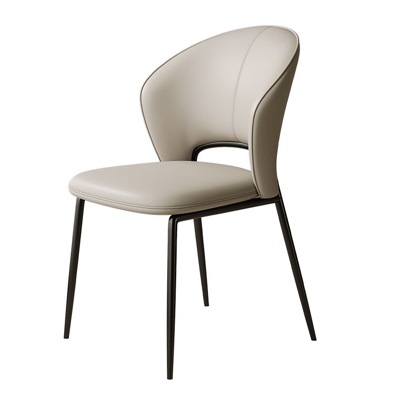 A sleek chair featuring a beige curved backrest and seat, complemented by slender black metal legs