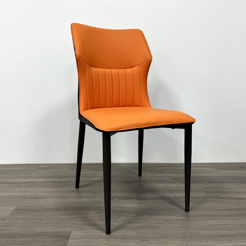 A striking chair with a terracotta leather seat, vertical stitching, and contrasting black legs