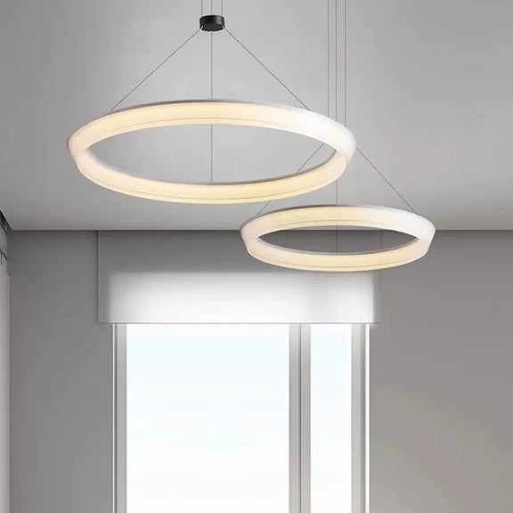 Modern halo ring chandelier in gold finish suspended over dining table