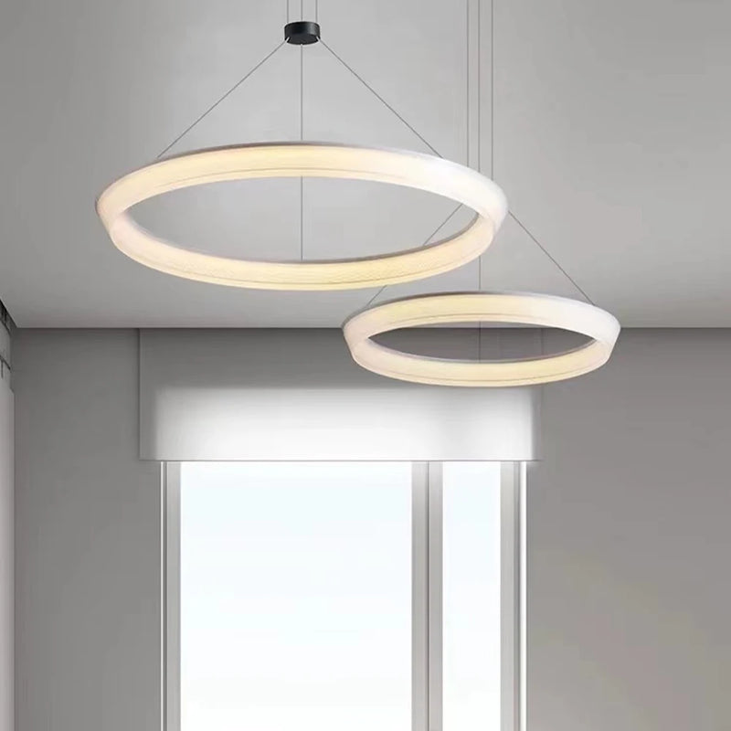 Modern halo ring chandelier in gold finish suspended over dining table